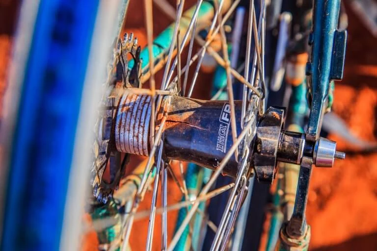 Detailaufnahme einer alten Fahrradnabe mit rostigem Mechanismus und verzwickten Speichen in Nahaufnahme