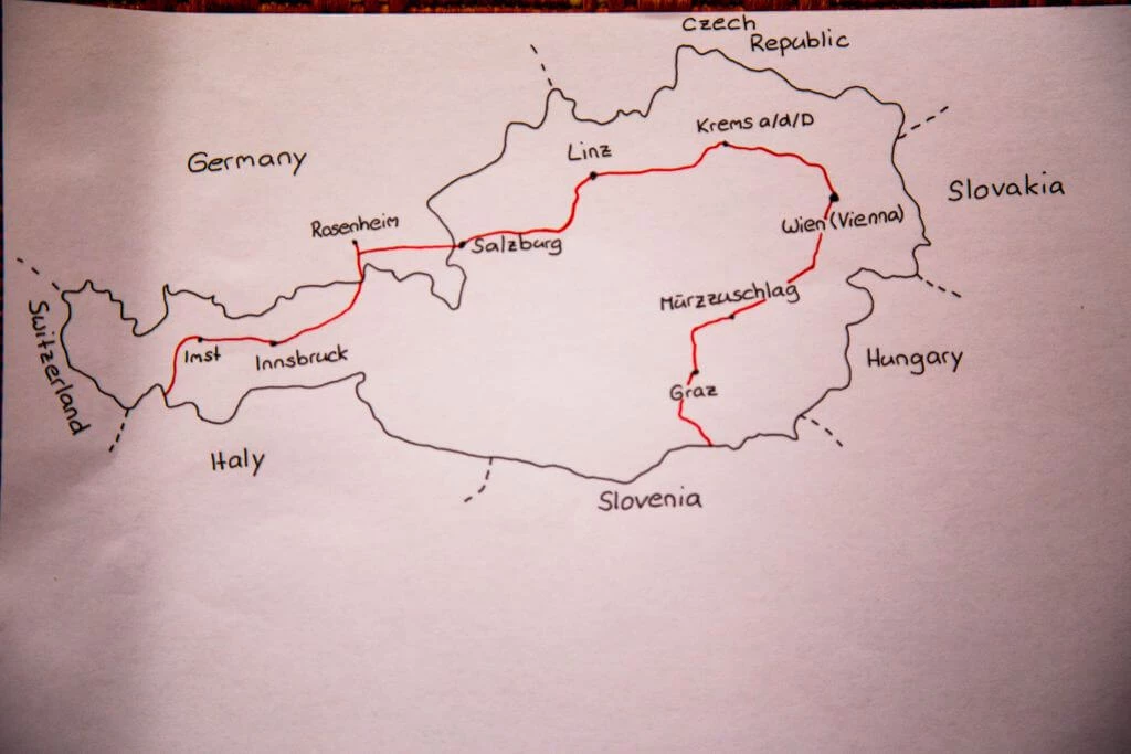 Handgezeichnete Landkarte von Österreich mit rot markierter Fahrradstrecke durch mehrere Bundesländer und Nachbarländer