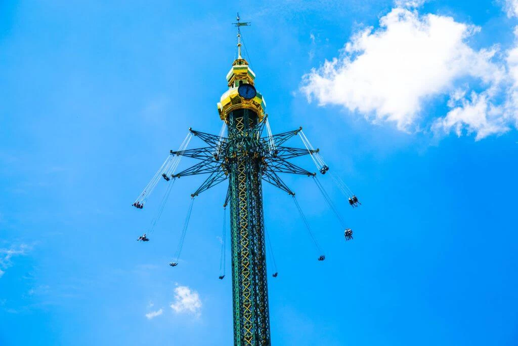 Hohe Riesenradanlage mit goldener Spitze, rotierend vor blauem Himmel mit Wolken