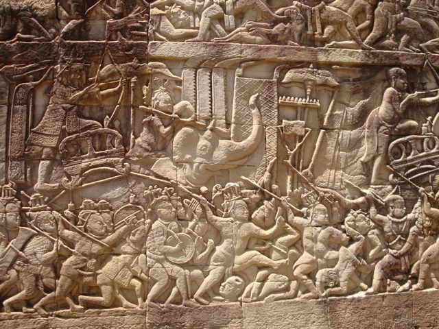 Detailliertes Steinrelief mit kämpfenden Figuren, historische Darstellung aus der Khmer-Architektur mit vielen Kriegern und Szenen