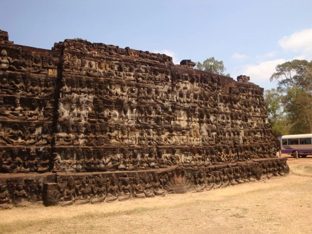 Historische Steinmauer mit vielen reliefierten Köpfen und Figuren, Teil der Terrasse der Lepra-Könige im Tempelkomplex von Angkor, Kambodscha