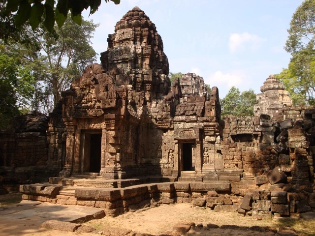 Historische Steinruine mit Türmen und Eingängen, Sandstein-Architektur, üppige Vegetation im Hintergrund
