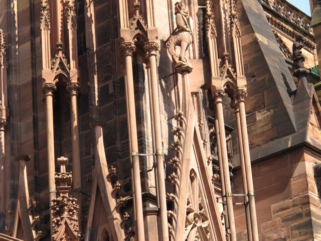 Nahaufnahme von kunstvoll verzierten gotischen Säulen und Steinmetzarbeiten einer Kathedrale in warmem Rosatönen