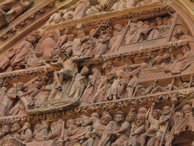 Detaillierte, dicht gedrängte mittelalterliche Steinmetzarbeit mit zahlreichen figürlichen Darstellungen in einem Kirchenportal