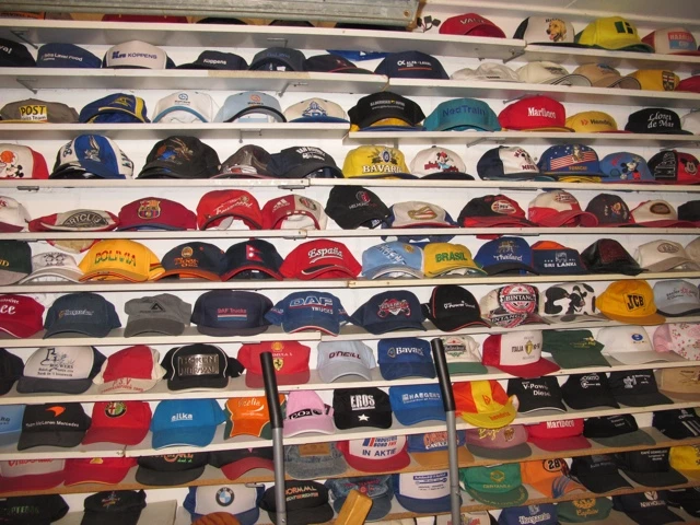 Regal mit vielen Reihen von Basecaps in verschiedenen Farben und Designs, dicht an dicht nebeneinander angeordnet