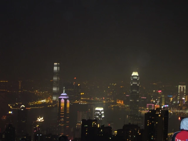 Nächtliche Stadtansicht von Hongkong mit beleuchteten Wolkenkratzern, verschwommene Lichter und dunkle Silhouetten der Hochhäuser
