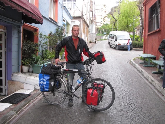 Beladenes Fahrrad auf einer gepflasterten Straße zwischen bunten Häusern in einer engen Istanbuler Seitenstraße