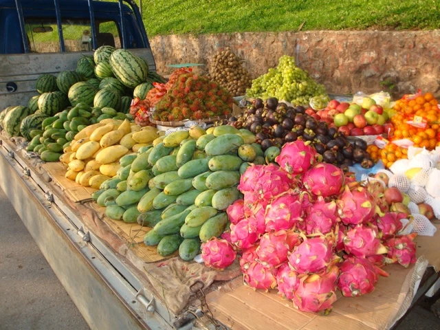 Lastwagen-Ladefläche mit verschiedenen Früchten wie Wassermelonen, Mangos, Drachenfrucht, Orangen und Ananas